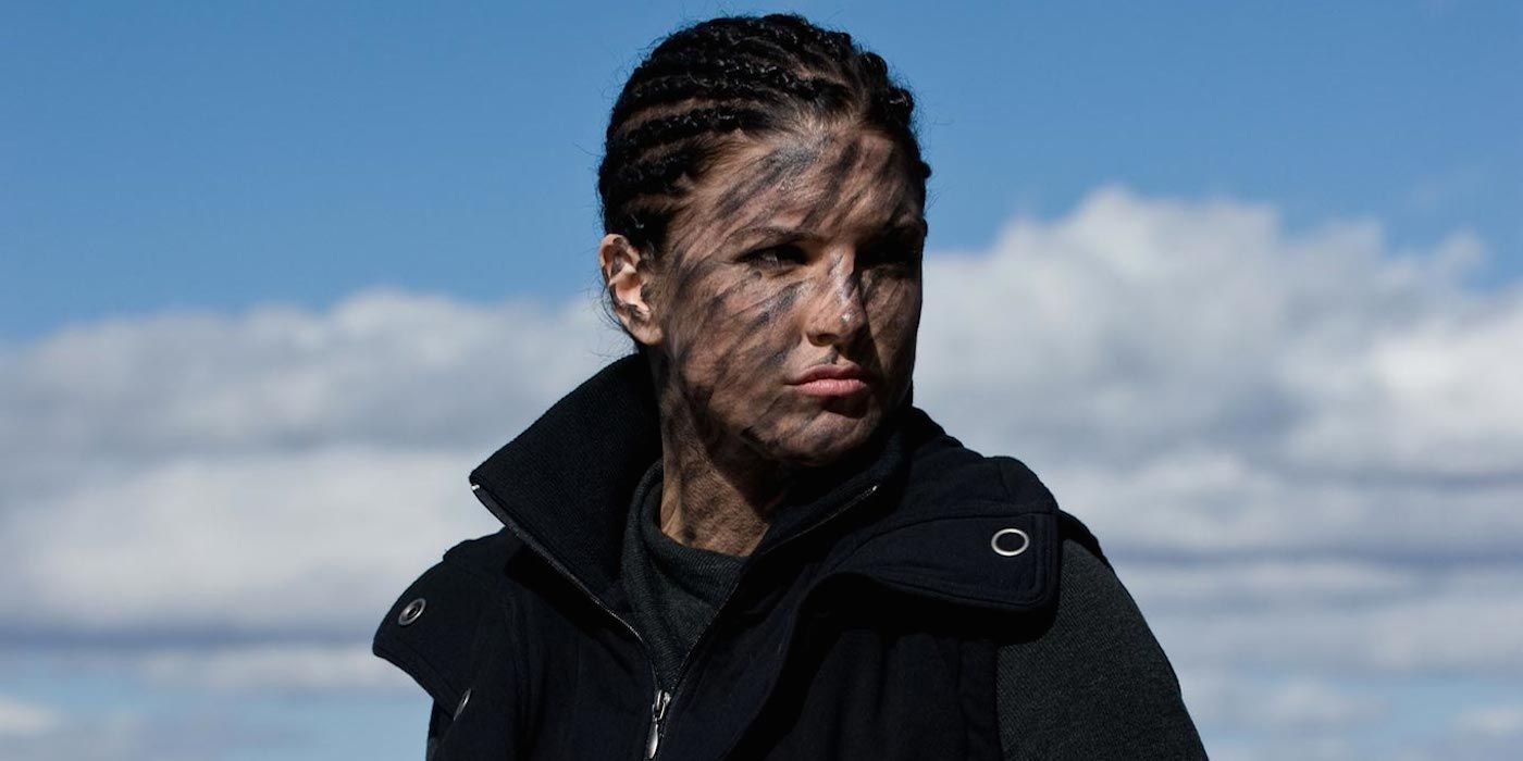 Mallory (Gina Carano) with face camo in front of a blue sky in Haywire