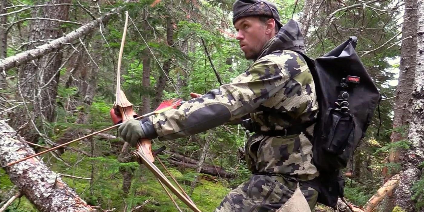 A contestant from Alone in the woods with his bow and arrow