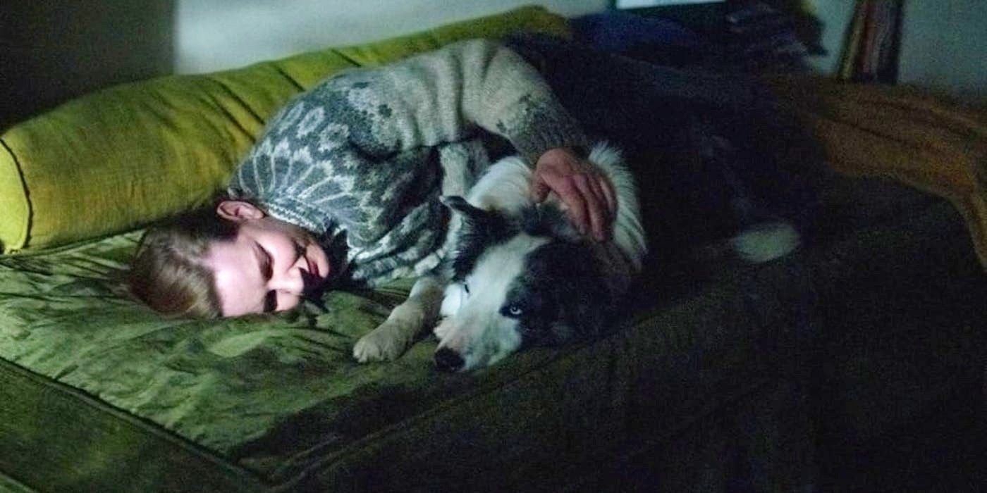 Sandra (Sandra Huller) cuddles with Snoop the dog at the end of Anatomy of a Fall