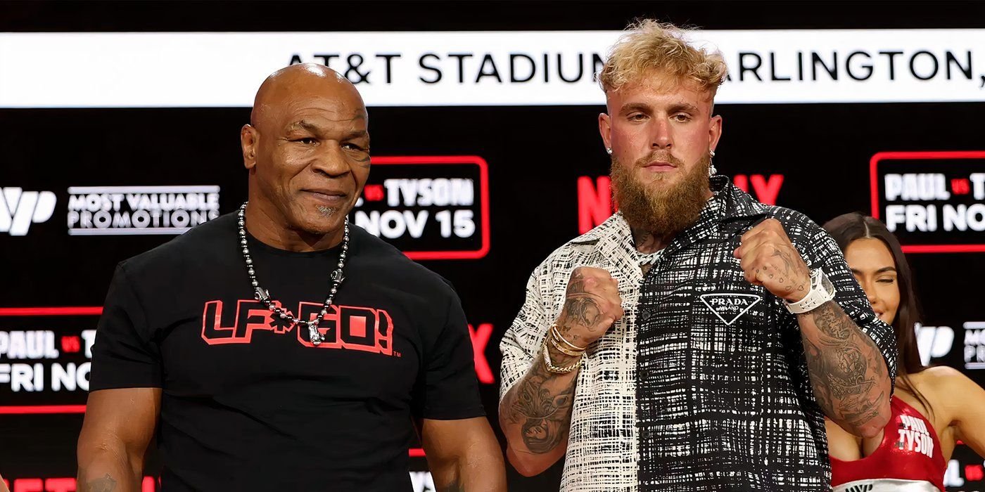 Why The Jake Paul vs. Mike Tyson Fight Was Delayed From July 2 Jake Paul and Mike Tyson posing for cameras at a press conference.