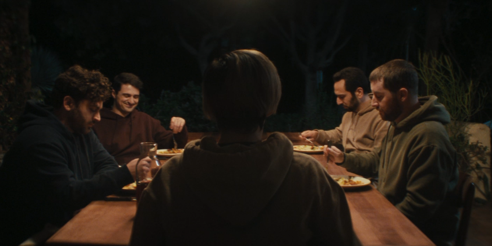 Still of the group sitting at a table in Daddy (2023)