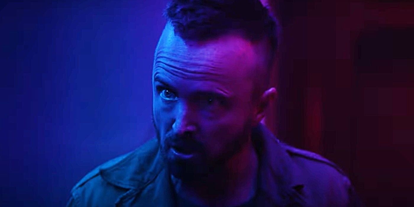 Aaron Paul speaking urgently in blue and purple hued lighting in Ash