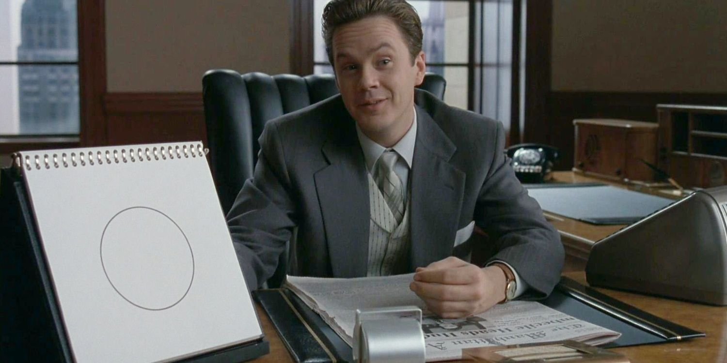 A man sitting behind a table in The Hudsucker Proxy