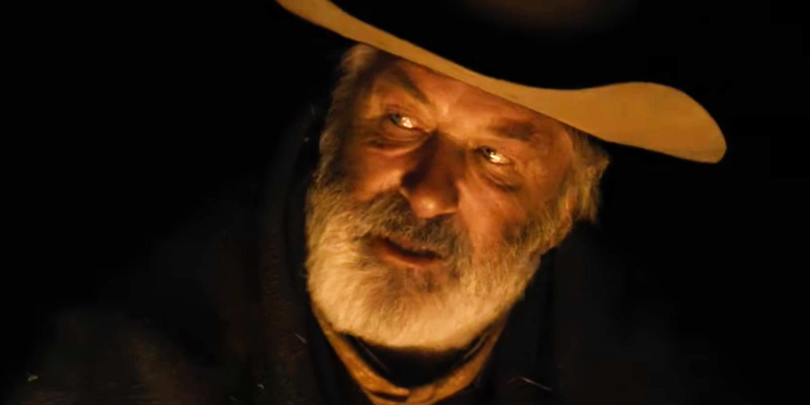 Alec Baldwin Rust wearing a cowboy hat sitting by the fire 
