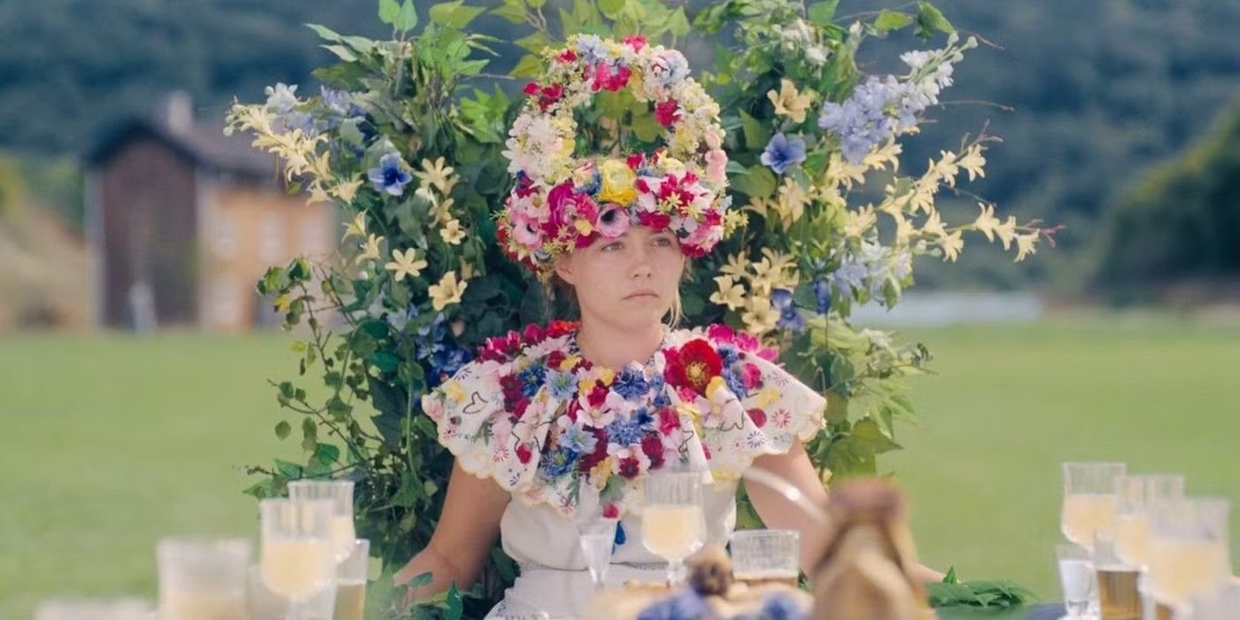 Dani (Florence Pugh) wears a flower crown and necklace while sitting in a flowery chair in Midsommar