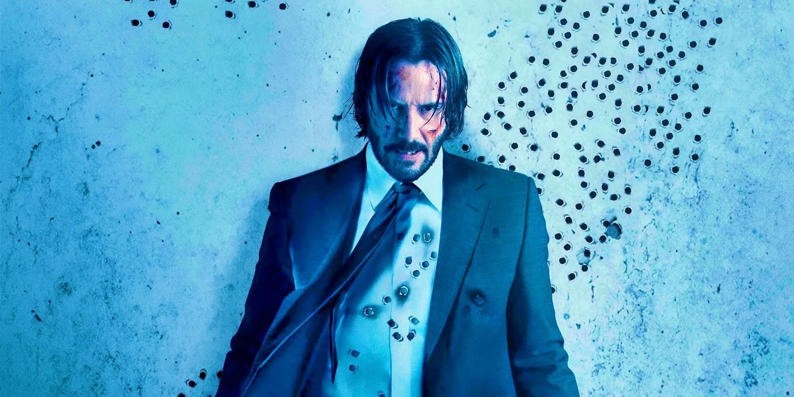John Wick (Keanu Reeves) riddled with bullets and standing against a wall covered in bullet holes