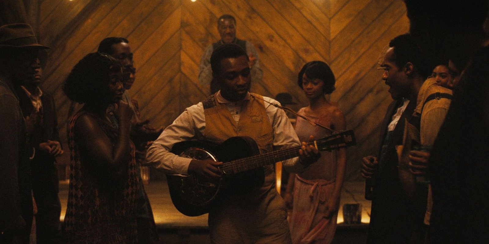 Miles Caton as Sammie "Preacher Boy" Moore playing guitar in Club Juke in Sinners