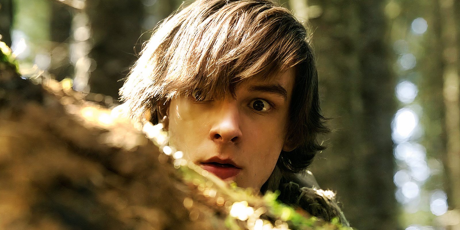 Mason Thames as Hiccup hiding behind a rock in How to Train Your Dragon 2025
