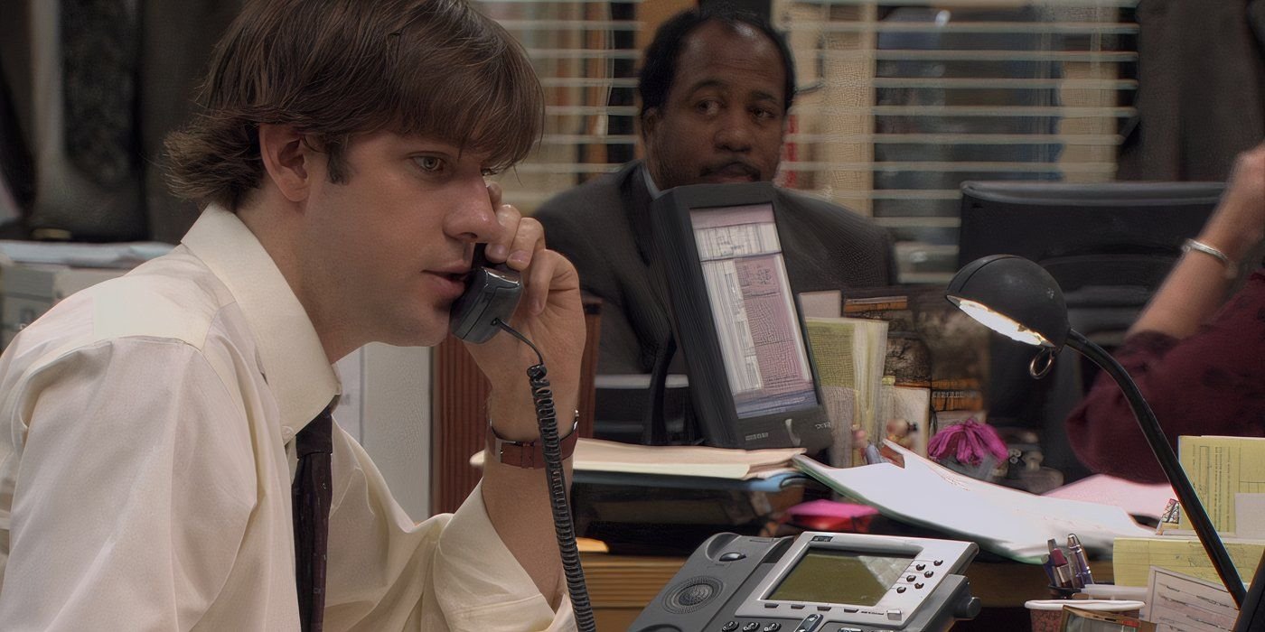 Jim sat at his desk and talking on the phone to his client in The Office season 1 episode “Diversity Day.”