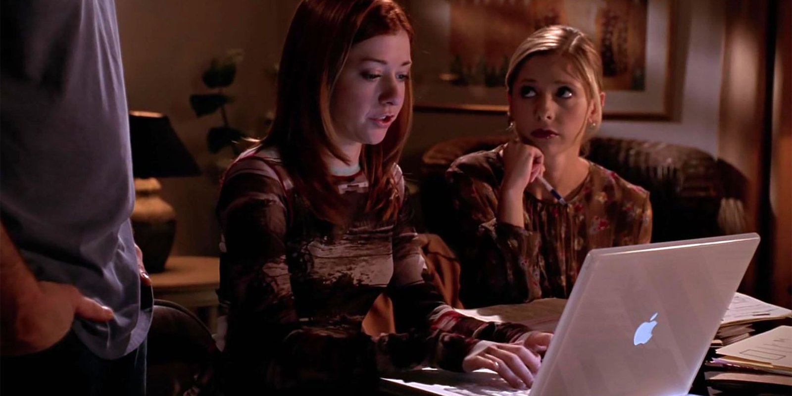 Willow (Alyson Hannigan) types on a laptop computer as Buffy (Sarah Michelle Gellar) looks aside in Buffy the Vampire Slayer season 7 Help