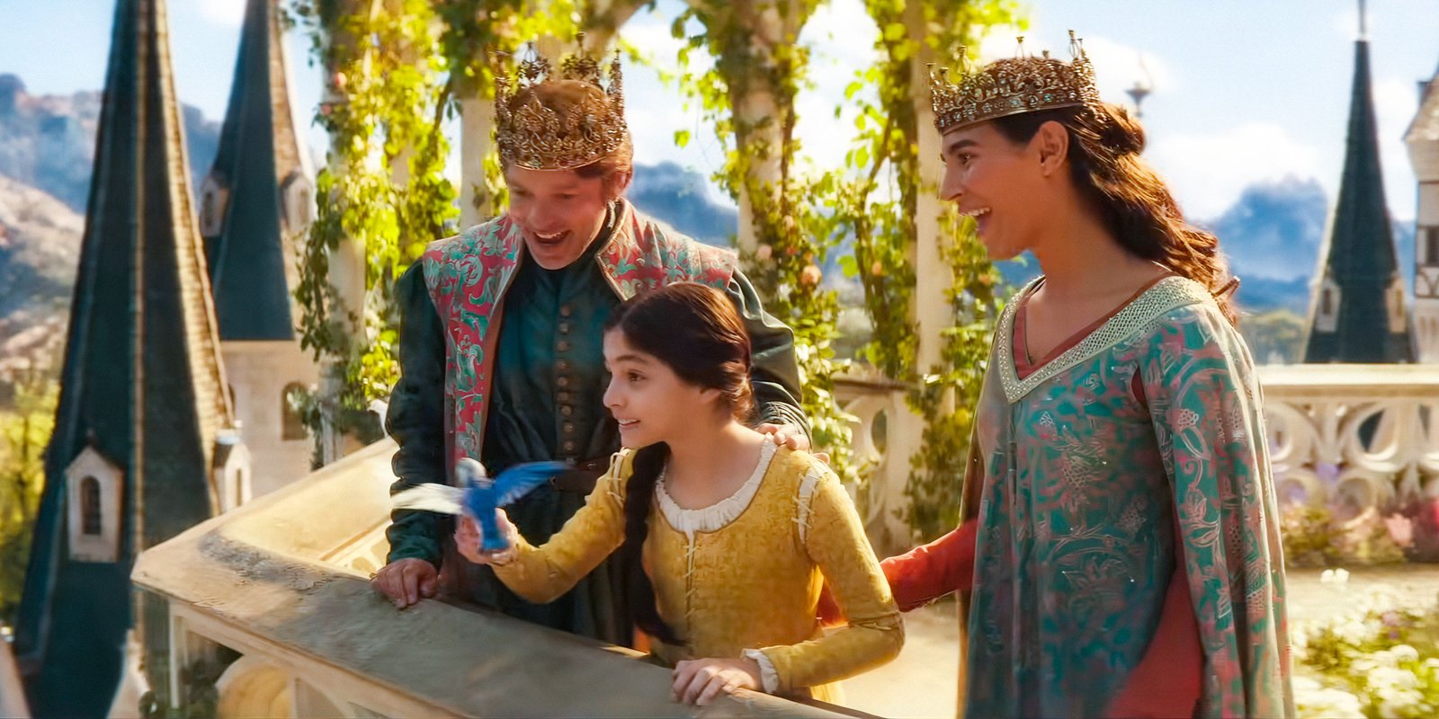 Good King (Hadley Fraser), Good Queen (Lorena Andrea), and Young Snow White (Emilia Faucher) with a little blue bird in Snow White (2025)
