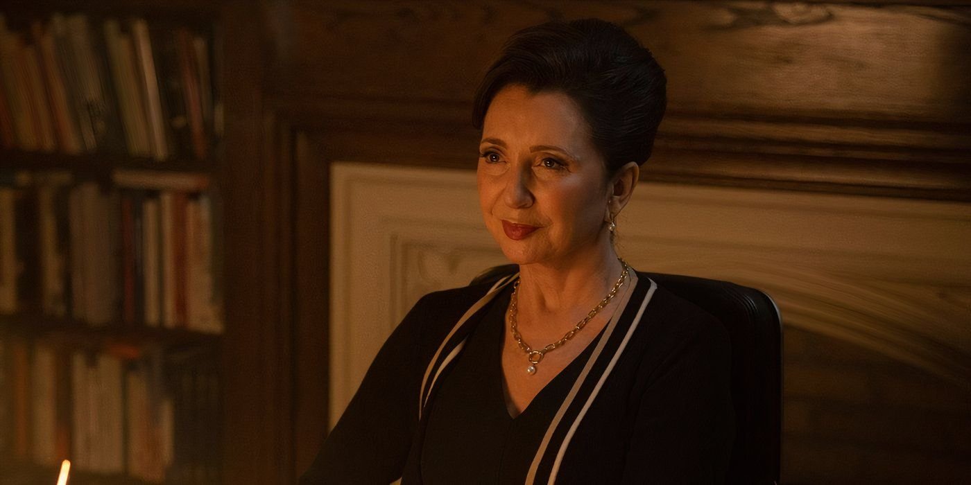  Donna Murphy smirks slightly while sitting behind her desk in Brilliant Minds