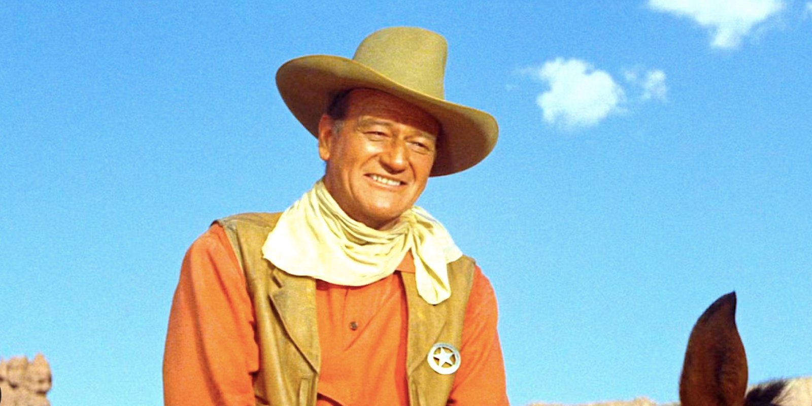 John Wayne smiles on horseback in The Comancheros