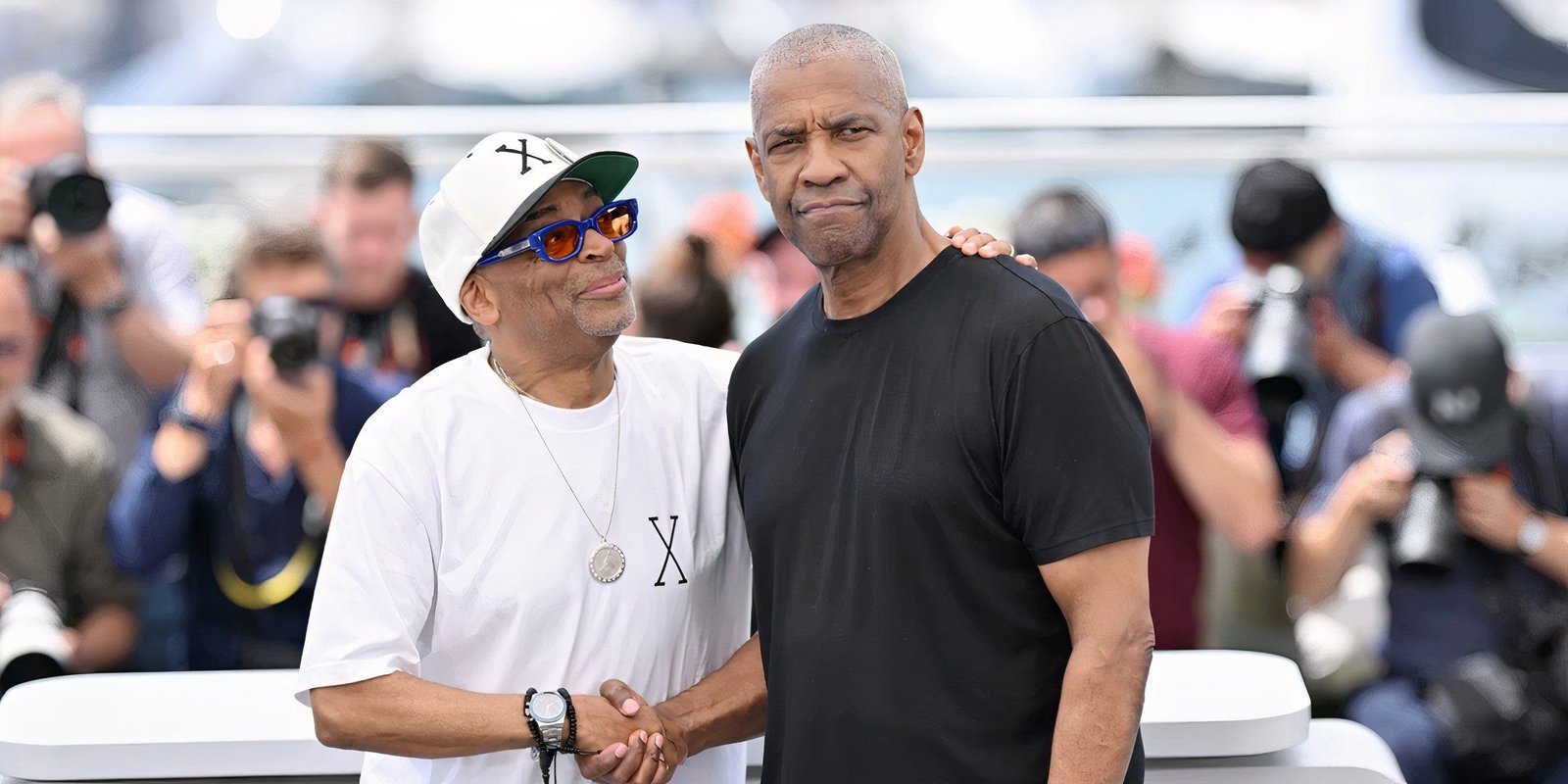 Denzel Washington shakes hands with Spike Lee on the red carpet 