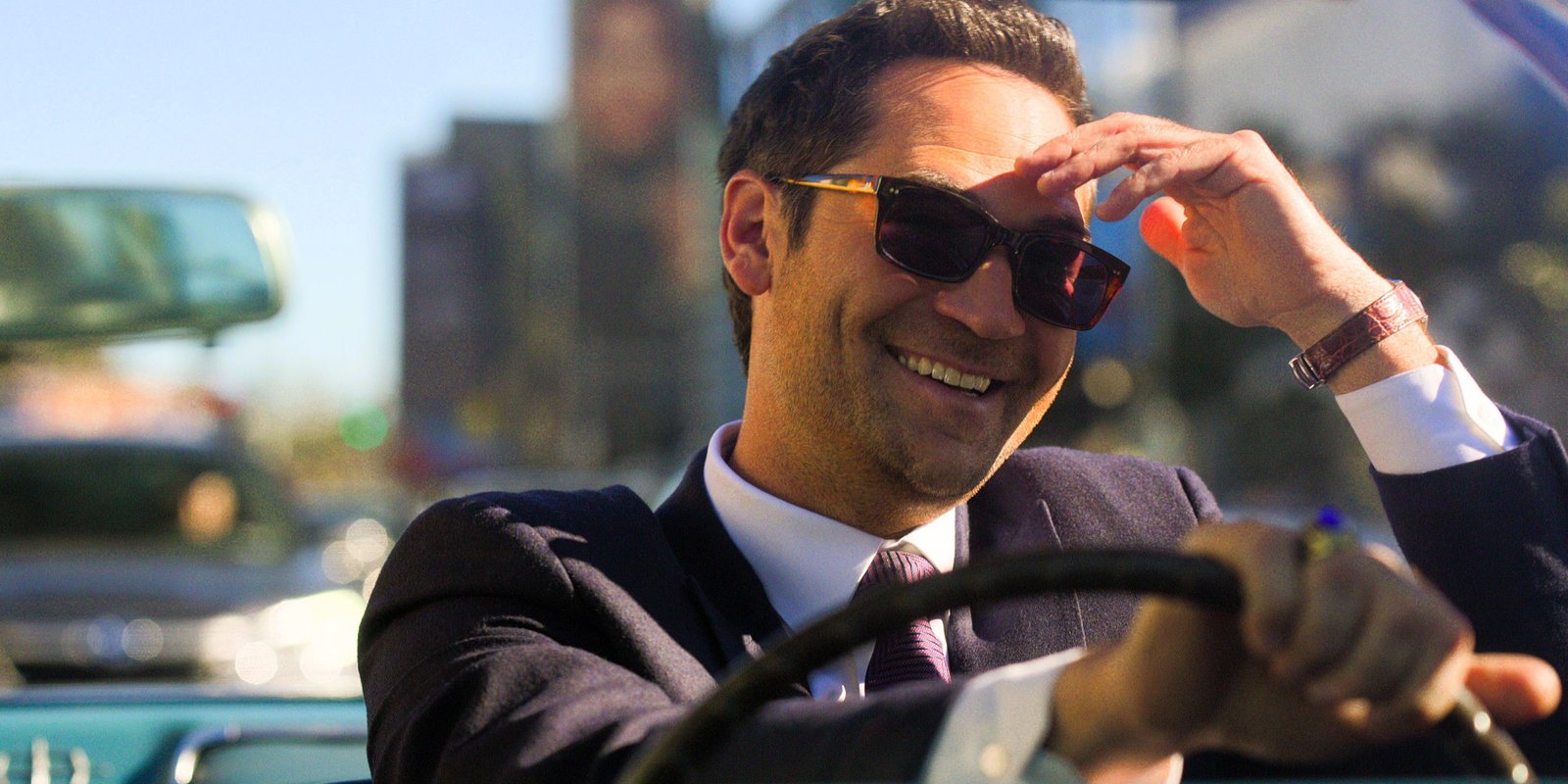Mickey Haller smiles while driving the car in The Lincoln Lawyer