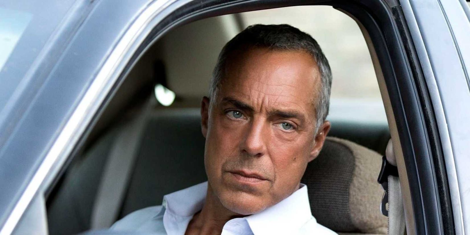 Bosch (Titus Welliver) leaning out a car and staring at something in Bosch.