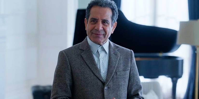 Adrian Monk (Tony Shalhoub) standing in front a piano and smiling in Mr. Monk's Last Case: A Monk Movie