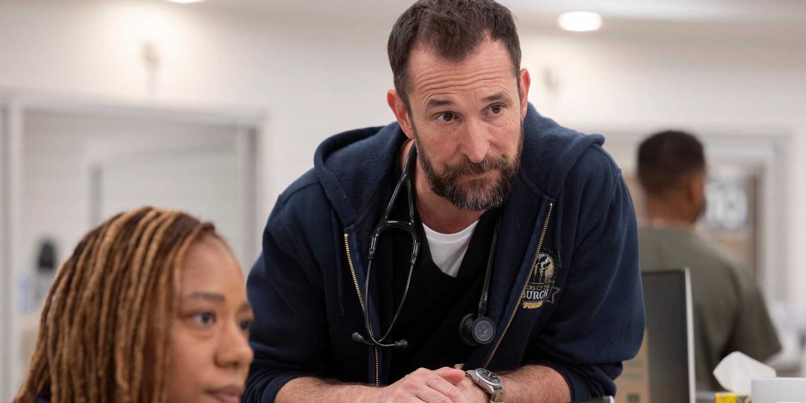 Dr. Robby (Noah Wyle) at work in the hospital looking at something offscreen in The Pitt