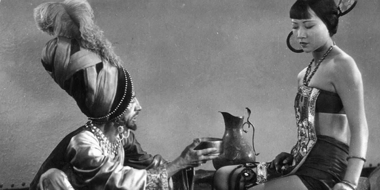 A screenshot of Anna May Wong's Mongol slave being accosted by her Mongol captor from The Thief of Bagdad