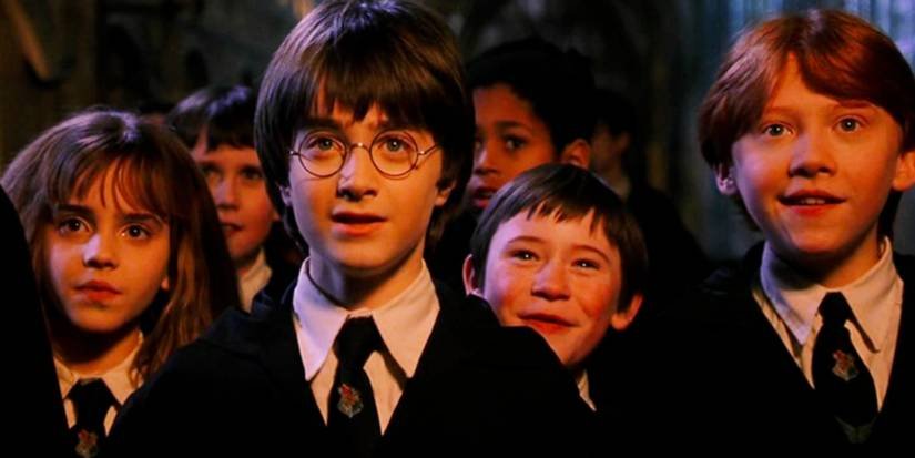 Hermione, Harry, Seamus, and Ron staring ahead in amazement in Harry Potter and the Sorcerer's Stone.