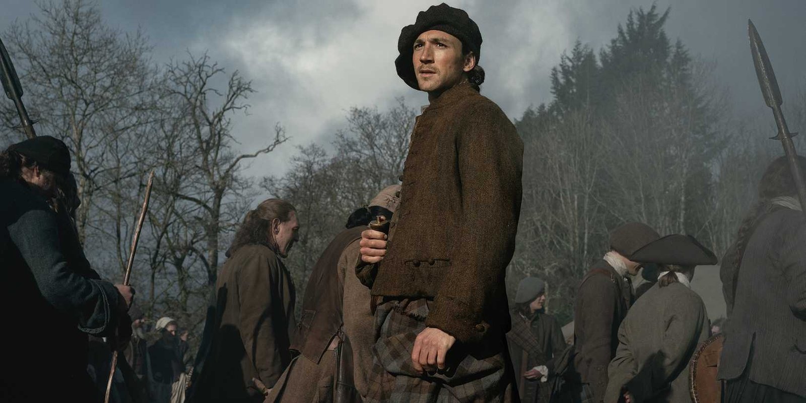 Rory Alexander's Murtagh looking into the distance while standing in a crowd in Outlander: Blood of My Blood