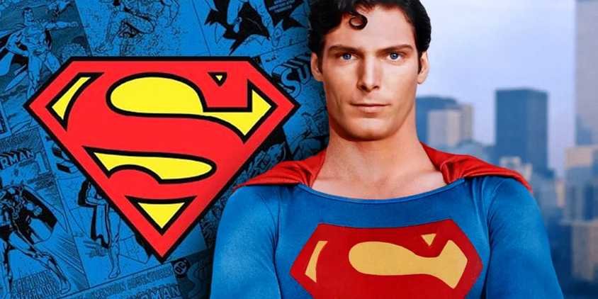 Christopher Reeve superman stood next to his iconic logo