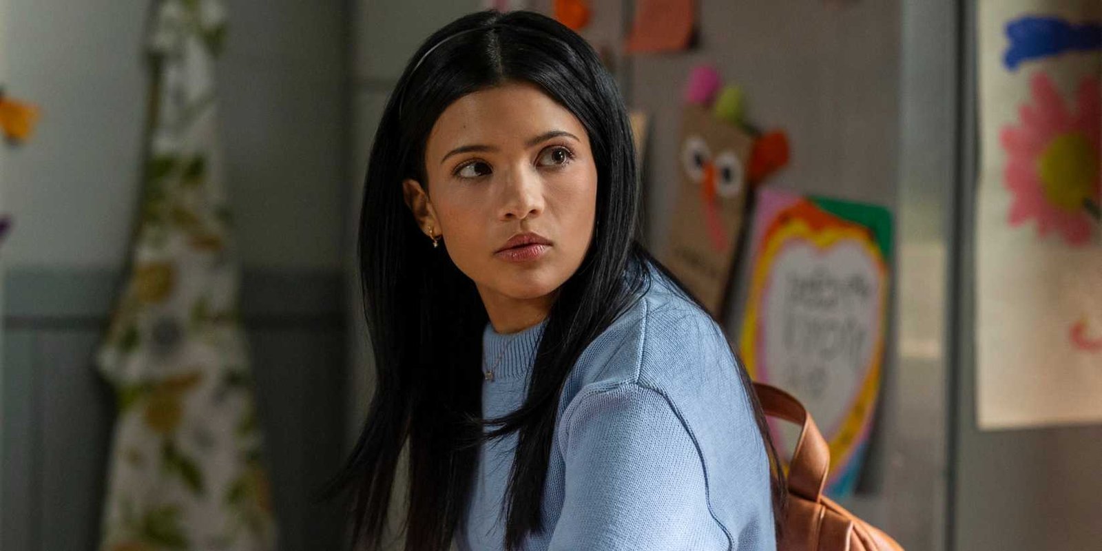 Jackie Howard looks over her shoulder while wearing a blue sweater in My Life With the Walter Boys season 2