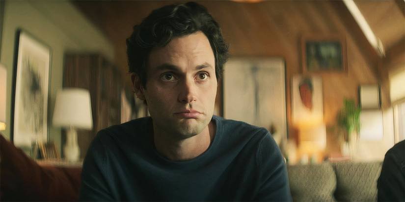 Penn Badgley as Joe Goldberg sitting on a couch in You season 3