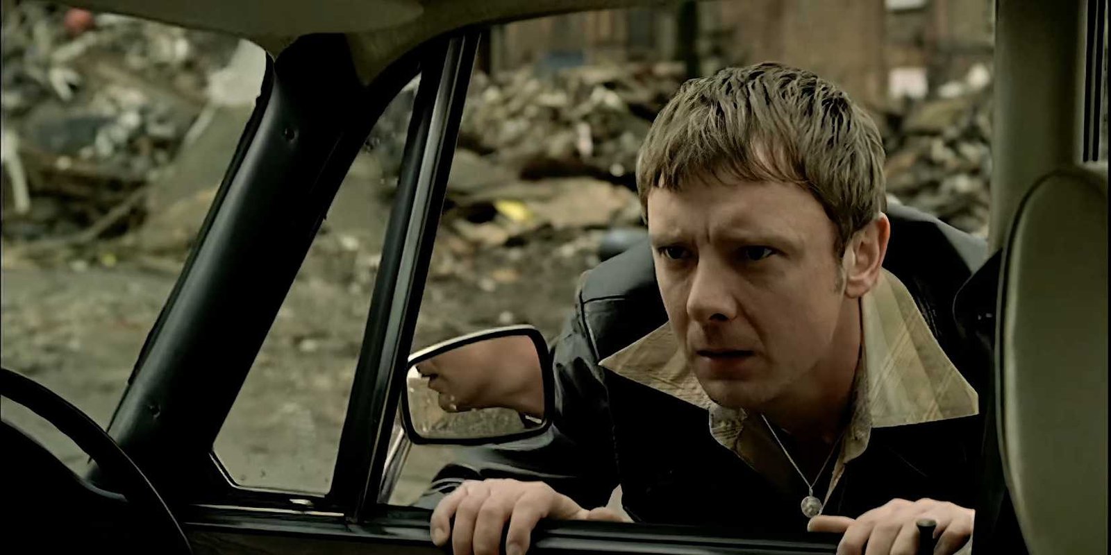 John Simm as Sam Tyler peering into a car as he talks to an off-screen police officer in Life on Mars.