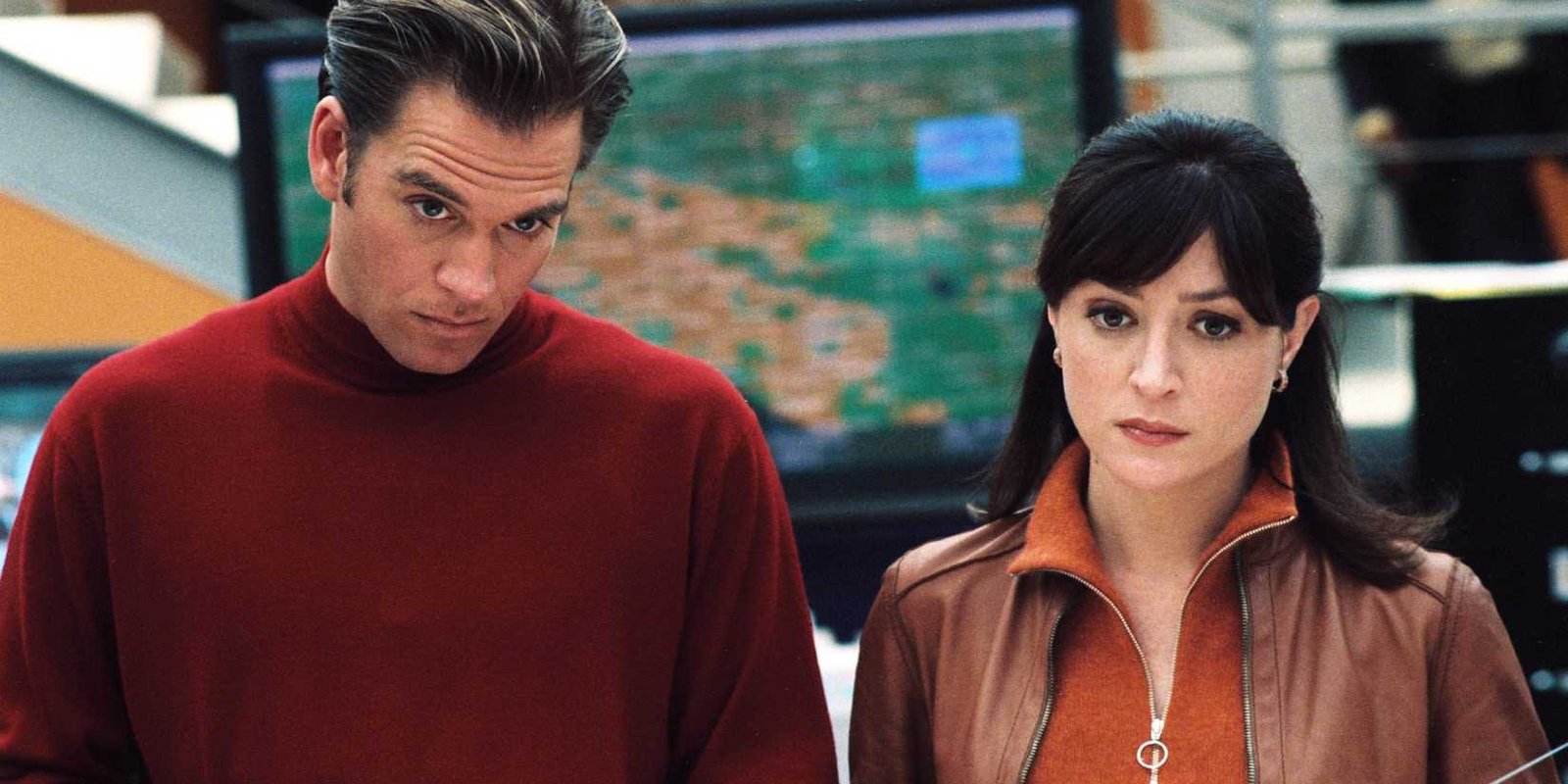 Tony (Michael Weatherly) and Cate (Sasha Alexander) looking at something off screen in NCIS season 1